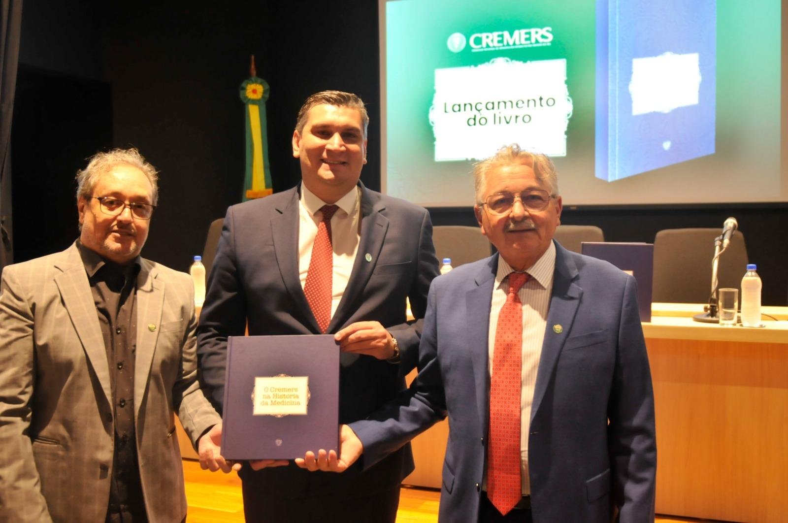 Presidente do Cremers, Carlos Sparta (c), ao lado do jornalista Elizi&aacute;rio Goulart Rocha (e) e do m&eacute;dico mastologista e conselheiro do Cremers, Jos&eacute; Luiz Pedrini, que editaram o livro "O Cremers na hist&oacute;ria da Medicina"