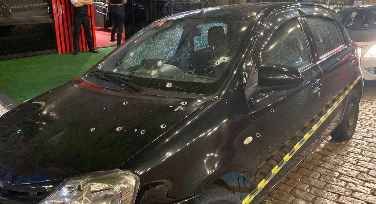 Ve&iacute;culo ficou crivado de tiros em frente a um bar