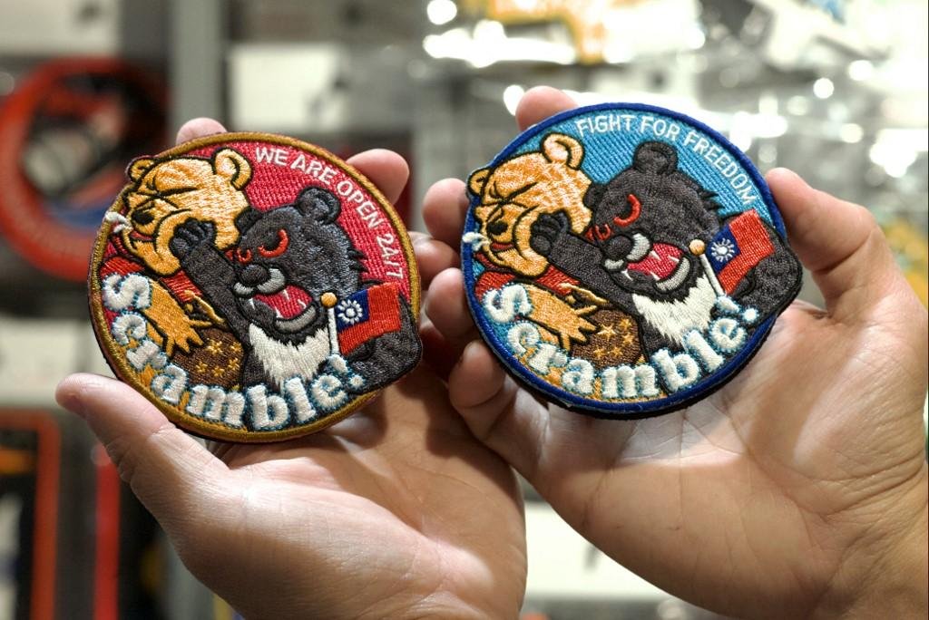 Patches representando um urso preto com a bandeira de Taiwan e socando Pooh numa loja em Taoyuan