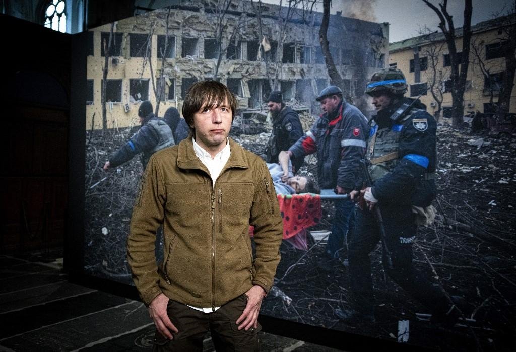 Fot&oacute;grafo Evgeniy Maloletka, com imagem premiada ao fundo
