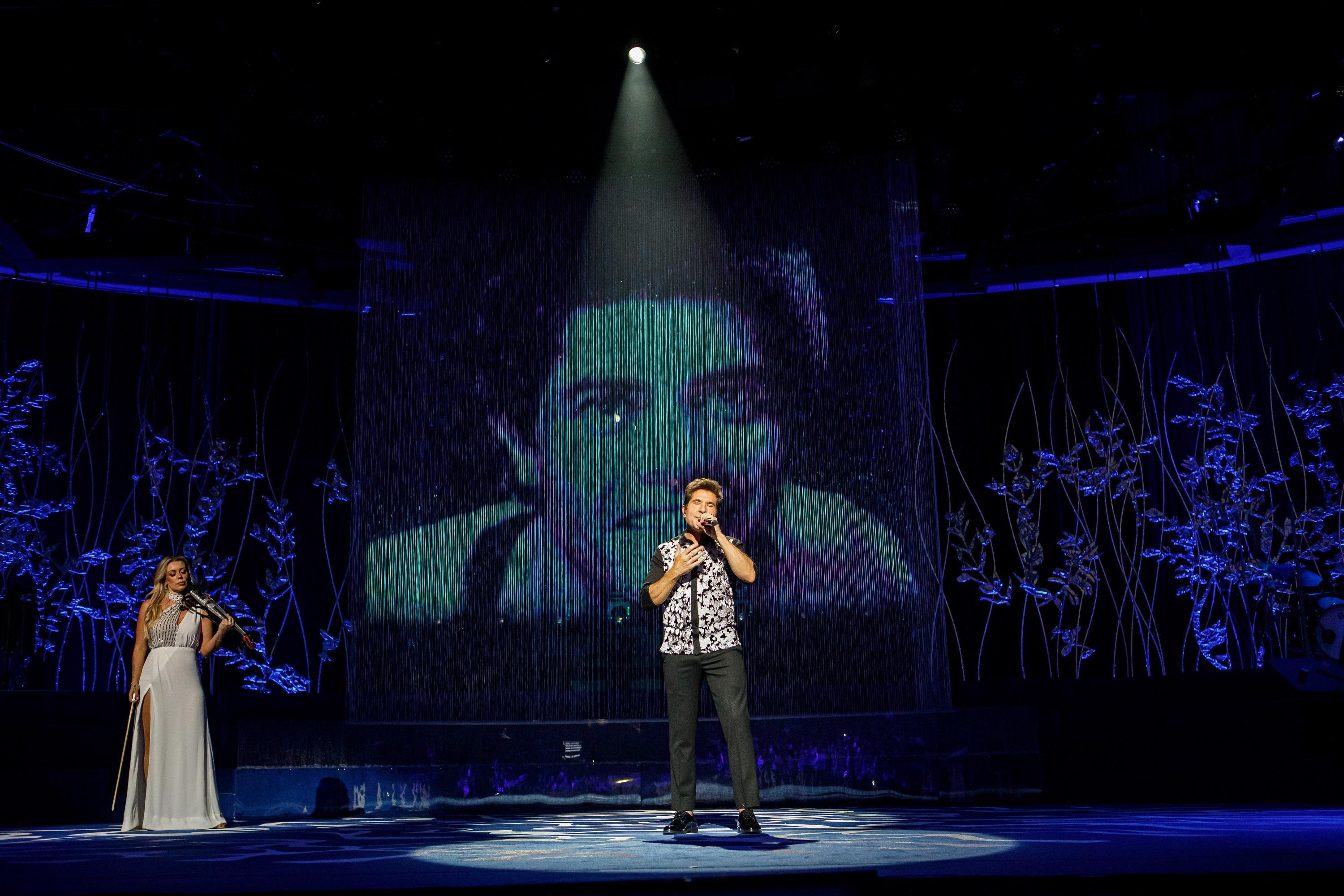 Daniel com a imagem do parceiro Jo&atilde;o Paulo, morto em 1997, projetada ao fundo em show de 40 anos de carreira