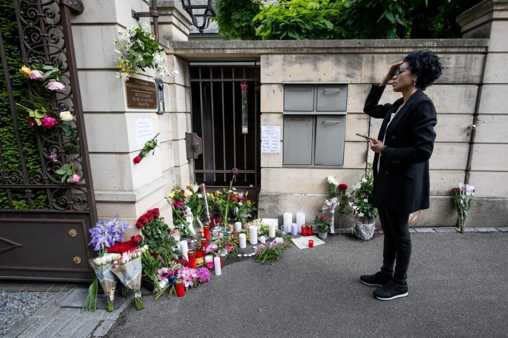 Velas e flores s&atilde;o deixadas do lado de fora da resid&ecirc;ncia da cantora