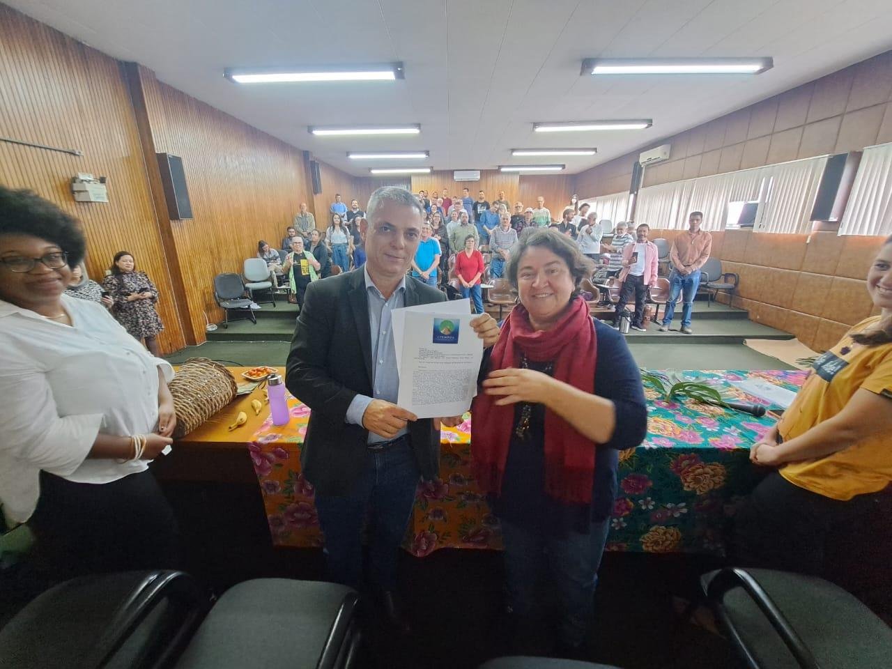 O secret&aacute;rio municipal de Governan&ccedil;a Local e Coordena&ccedil;&atilde;o Pol&iacute;tica, Cassio Trogildo, recebeu o documento das m&atilde;os da coordenadora do CFEMPOA, Iliete Aparecida Citadin.