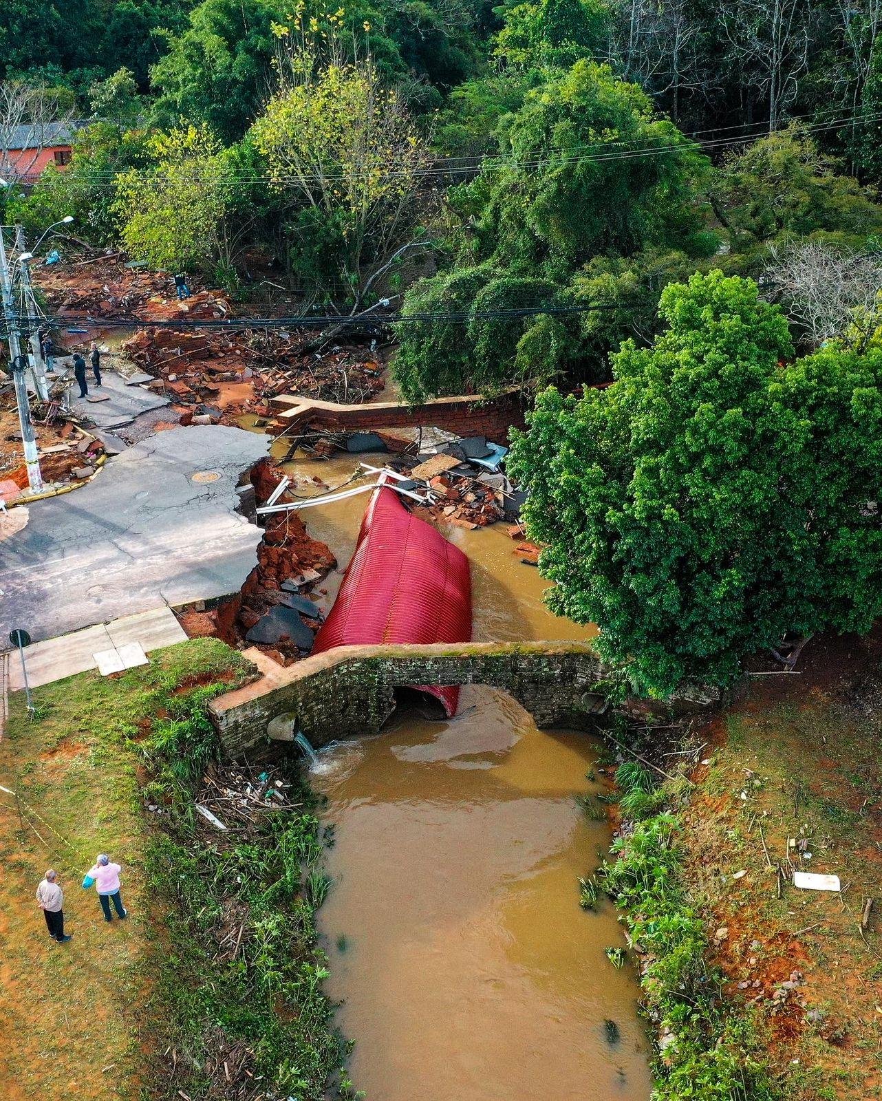 Entre os danos est&aacute; a destrui&ccedil;&atilde;o de pontes em comunidades fortemente atingidas pelas &aacute;guas, como no bairro Santo Andr&eacute;