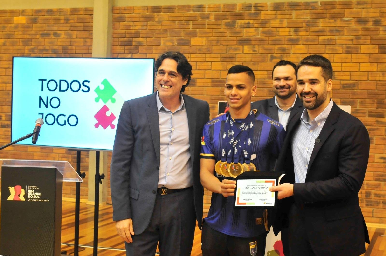 Secret&aacute;rio estadual de Esporte e Lazer, Danrlei de Deus e governador Eduardo Leite entregam homenagem ao paratleta Adenilson Duarte.