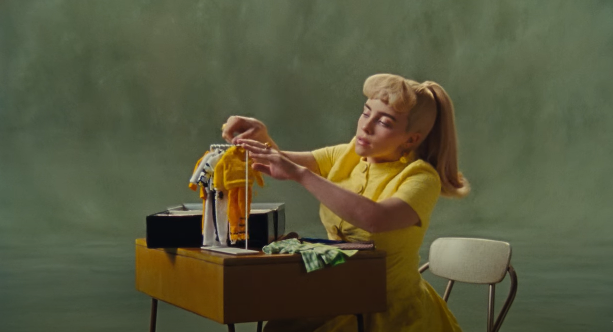 Videoclipe apresenta uma Billie Eilish caracterizada de uma vers&atilde;o mais antiga da Barbie e sozinha, organizando trajes de boneca em uma mesa