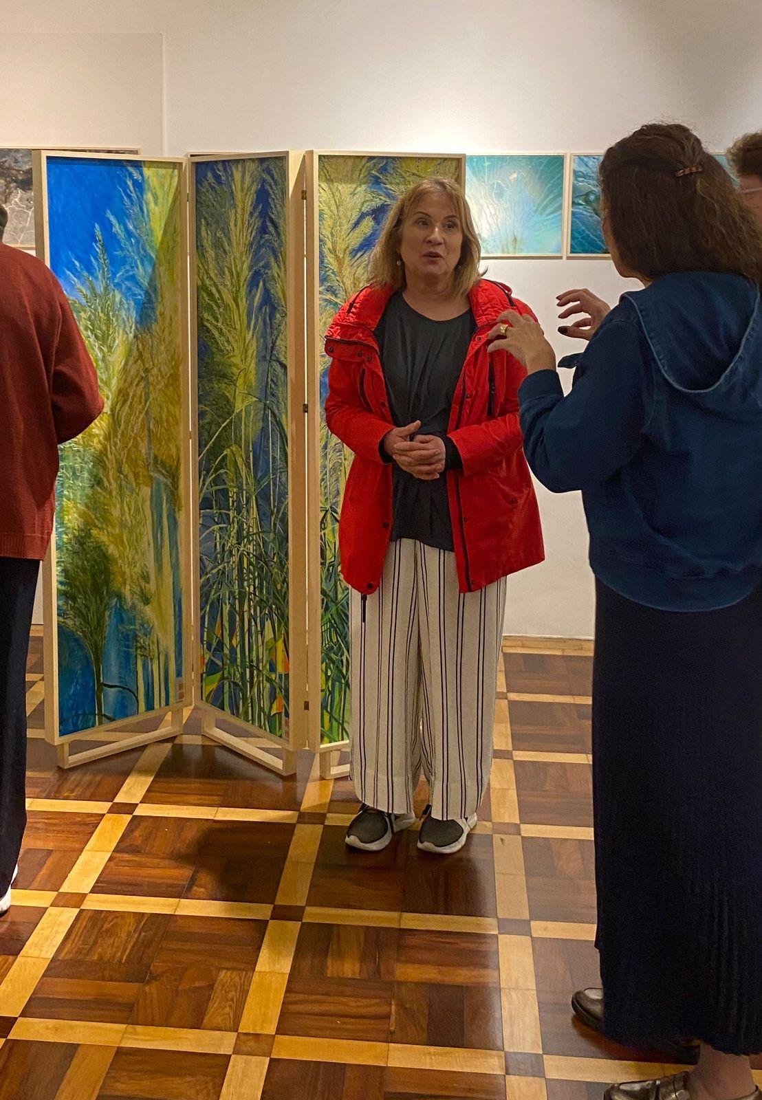 A artista visual M&aacute;rcia Rosa (de vermelho) participa de evento da Galeria 506