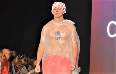 Fred Beyer subiu na passarela vestindo uma sacola pl&aacute;stica transparente, uma touca de banho e uma bermuda laranja