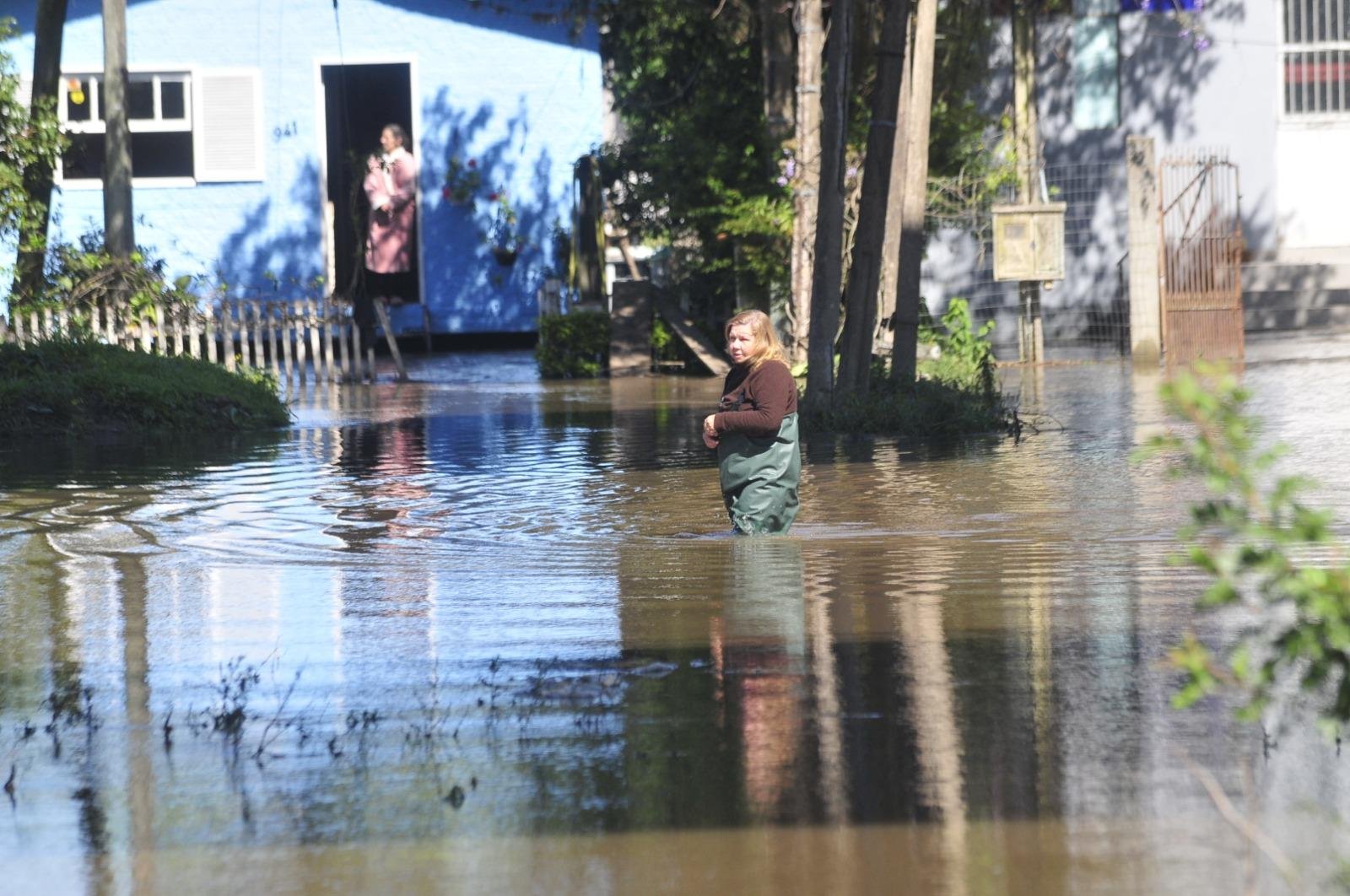 A moradora Maria Clair Pinto, do bairro Picada, precisa atravessar no meio da &aacute;gua para buscar mantimentos