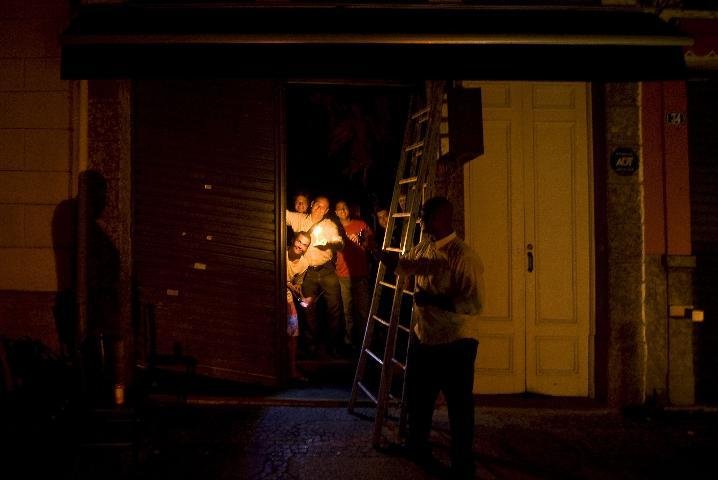 Clientes de restaurante jantam &agrave; luz de velas