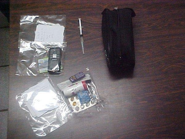 Seringa com morfina apreendida na bolsa da acusada