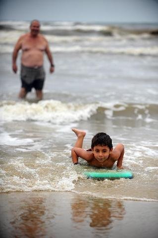 Condi&ccedil;&otilde;es clim&aacute;ticas ruins n&atilde;o impediram o pequeno Jo&atilde;o Vitor Sarmento da Silva, de 5 anos, de surfar com a sua prancha