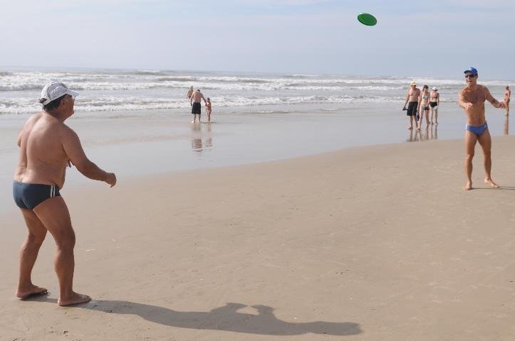 Ant&ocirc;nio e Carlo jogam frisbe na beira do mar