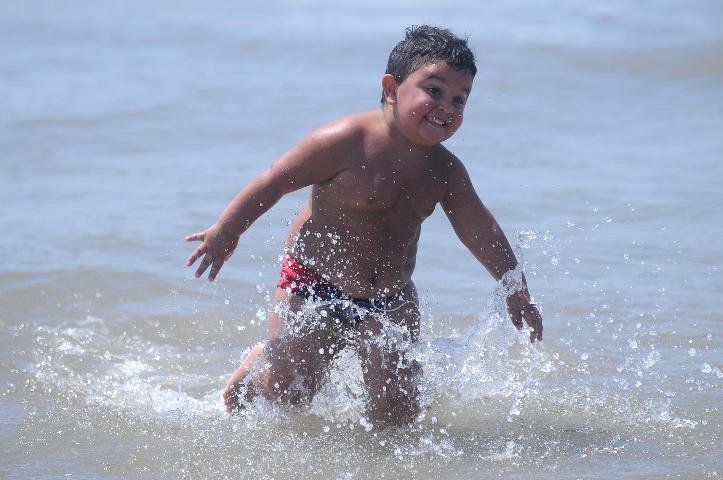 Crian&ccedil;ada aproveitou o dia quente para brincar na praia