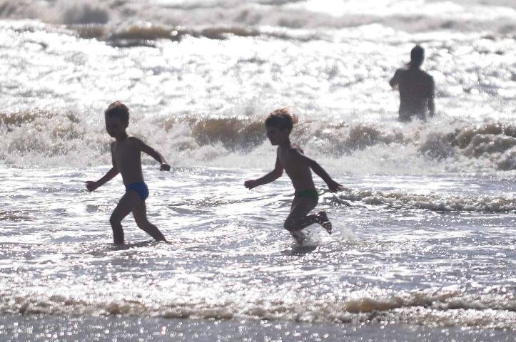 Crian&ccedil;as brincam no mar de Tramanda&iacute;, que est&aacute; com bandeira vermelha