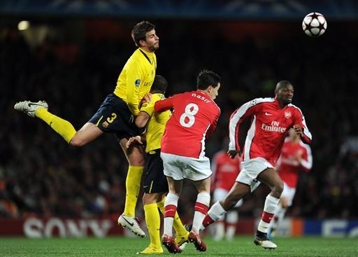O defensor Gerard Pique compete com o meia do Arsenal Samir Nasri