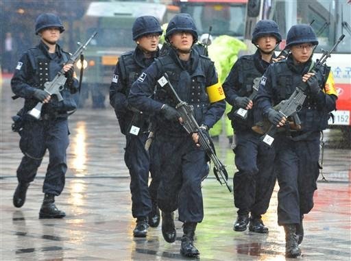Policiais sul-coreanos correndo para resgatar cidad&atilde;os supostamente atacados por terroristas norte-coreanos em Seul