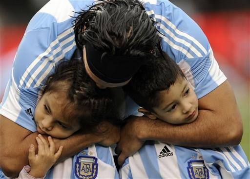 Tevez abra&ccedil;a duas crian&ccedil;as antes da vit&oacute;ria da Argentina de 5 a 0 sobre o Canad&aacute;