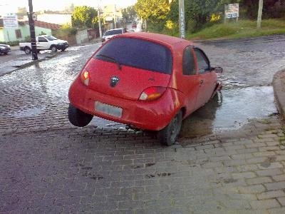 Roda de carro fica presa a buraco na zona Norte de Porto Alegre