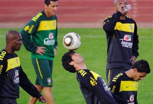 Jogador de futebol brasileiro Kak&aacute; (C) joga com a bola entre os companheiros de equipe