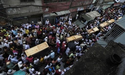 Moradores e parentes transportam os caix&otilde;es das v&iacute;timas do inc&ecirc;ndio em Bangladesh