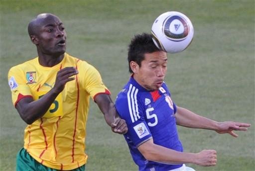O atacante camaron&ecirc;s Pierre Achille Webo luta pela bola com o zagueiro Yuto Nagatomo do Jap&atilde;o