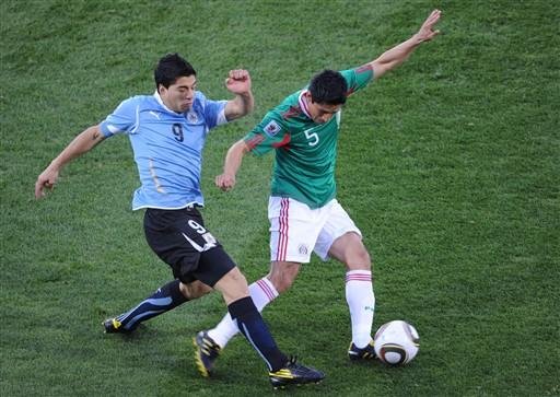O zagueiro mexicano, Ricardo Osorio, disputa a bola com o atacante uruguaio, Luis Suarez