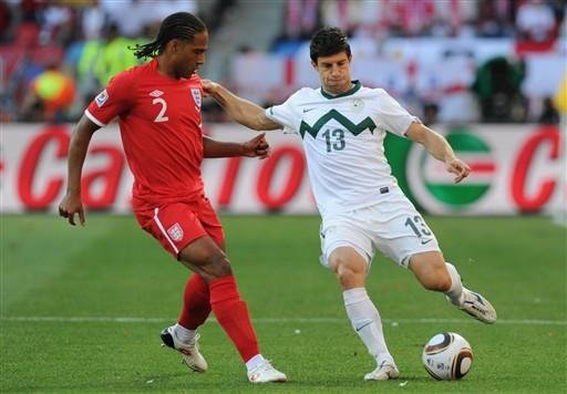 defensor da Inglaterra Glen Johnson (L) luta pela bola com o zagueiro da Eslov&eacute;nia, Bojan Jokic