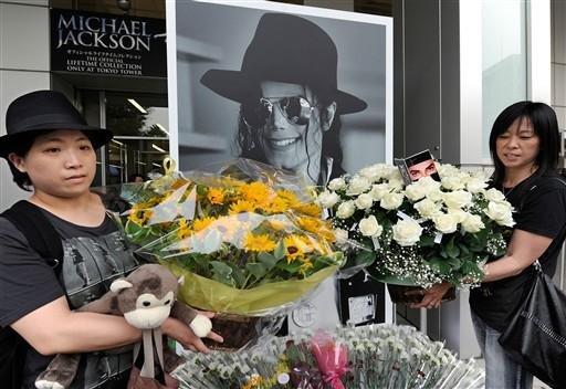 F&atilde;s depositam flores em frente a uma foto do Michael Jackson, no Jap&atilde;o. &Iacute;dolo morreu h&aacute; um ano