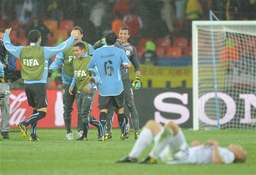 Jogadores do Uruguai comemoram a classifica&ccedil;&atilde;o &aacute; pr&oacute;xima fase enquanto o atacante sul-coreano, Park Chu-Young, desaba ap&oacute;s a derrota