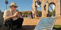 Homem esquenta água para chimarrão com energia solar