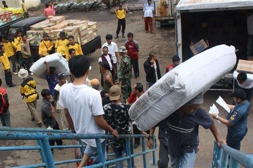 Trabalhadores socorrem as v&iacute;timas do tsunami nas ilhas Mentawai em um navio de abastecimento, no porto de Padang