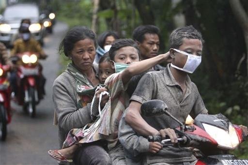 Moradores fogem de motocicleta durante a evacua&ccedil;&atilde;o de uma vila no distrito de Klaten