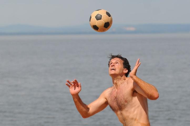 Mesmo com o sol forte, um grupo de amigos joga futev&ocirc;lei