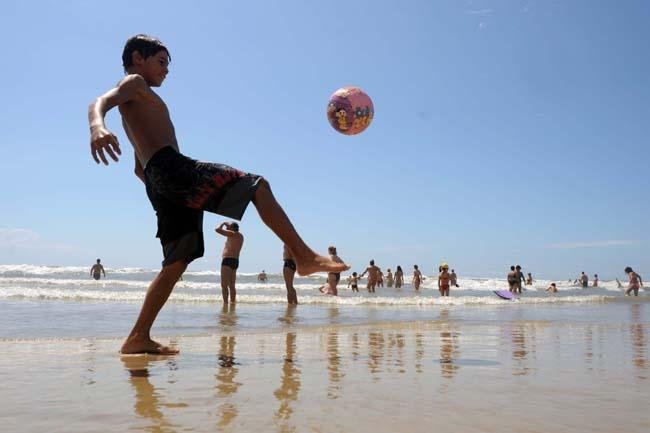 Manh&atilde; ensolarada e com mar calmo lota praias