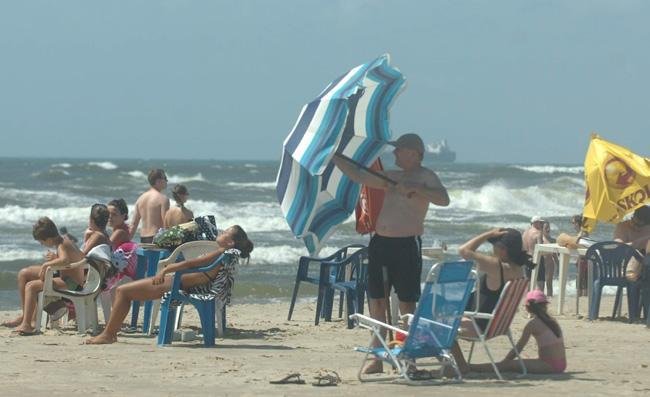 Com o vento, alguns banhistas tiveram dificuldades para abrir o guarda-sol