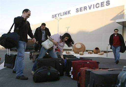 Funcion&aacute;rios do governo americano se preparam para embarcar no aeroporto de Cairo
