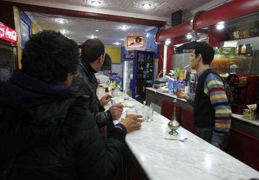 Clientes de um bar em Argel acompanham, pela televis&atilde;o, os confrontos no Egito