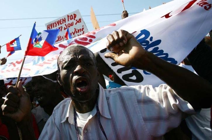 Aristide desceu do avi&atilde;o sorridente e foi recebido pelo secret&aacute;rio-geral da presid&ecirc;ncia haitiana