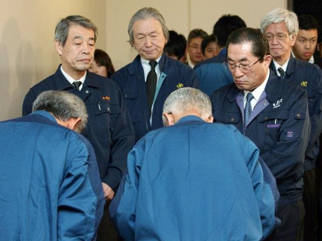 Presidente da companhia Tepco, Tsunehisa Katsumata, (segundo &agrave; dir.) se inclina para pedir desculpas a Ikuhiro Hattori, chefe de cooperativa de pescadores, em T&oacute;quio