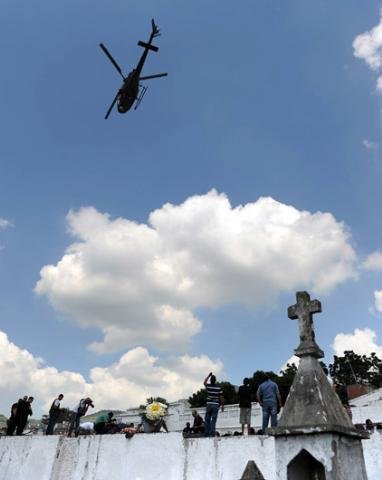 Helic&oacute;pteros jogam flores em sepultamento de alunos