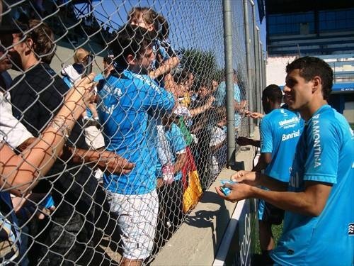 Jogadores do Gr&ecirc;mio distribuem chocolates ap&oacute;s o treino