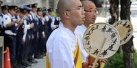 Monges budistas cantam em frente à sede da usina