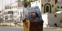 Em Trípoli, cartaz com rosto do ex-ditador é jogado no lixo