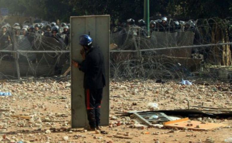 Homem usa porta de metal como escudo nos protestos no Cairo