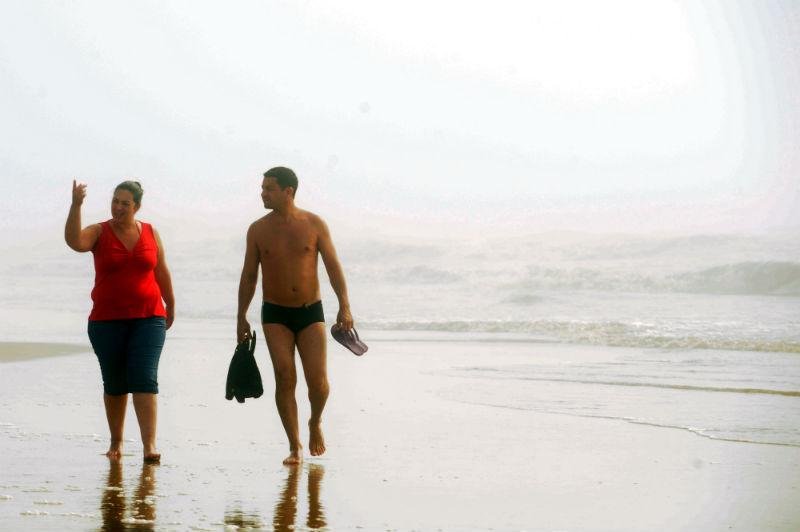 Muita gente caminhou pela beira da praia