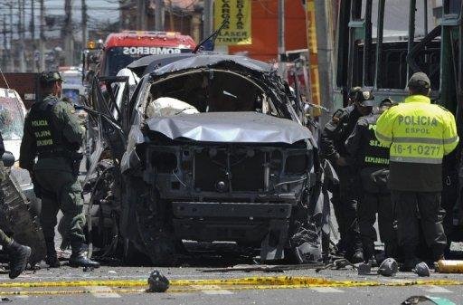 Policiais inspecionam os destro&ccedil;os do ve&iacute;culo de ex-ministro, ap&oacute;s explos&atilde;o de um carro-bomba