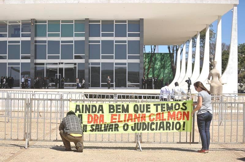 Manifestantes fixam cartaz na grade do STF como forma de protesto durante julgamento do mensal&atilde;o
