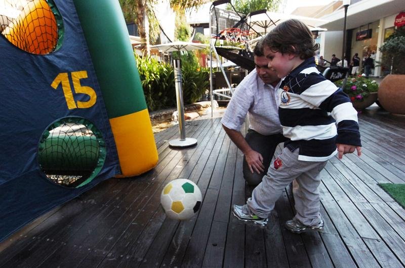 Pai ensina menino a jogar bola