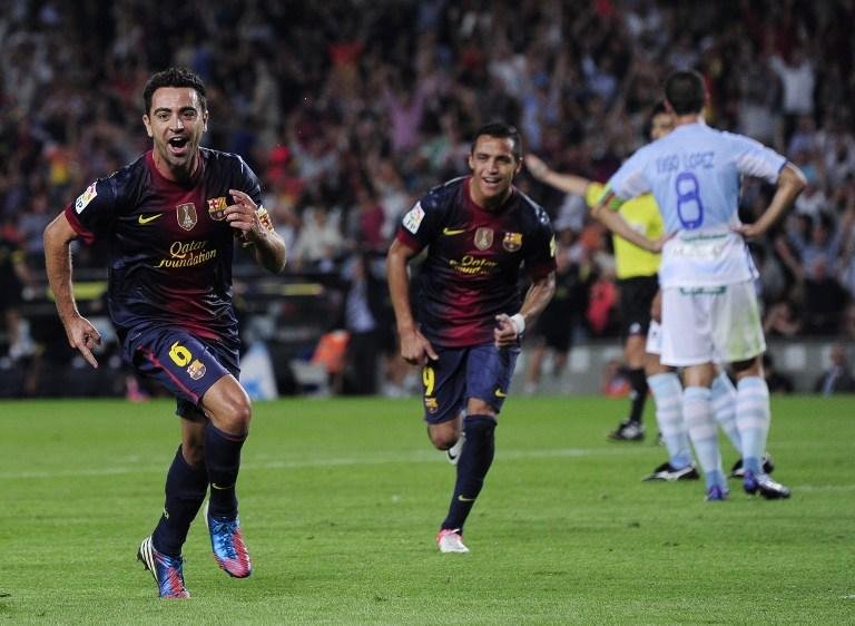 Xavi (&agrave; esquerda) apoia mosaico da torcida do Barcelona em cl&aacute;ssico espanhol